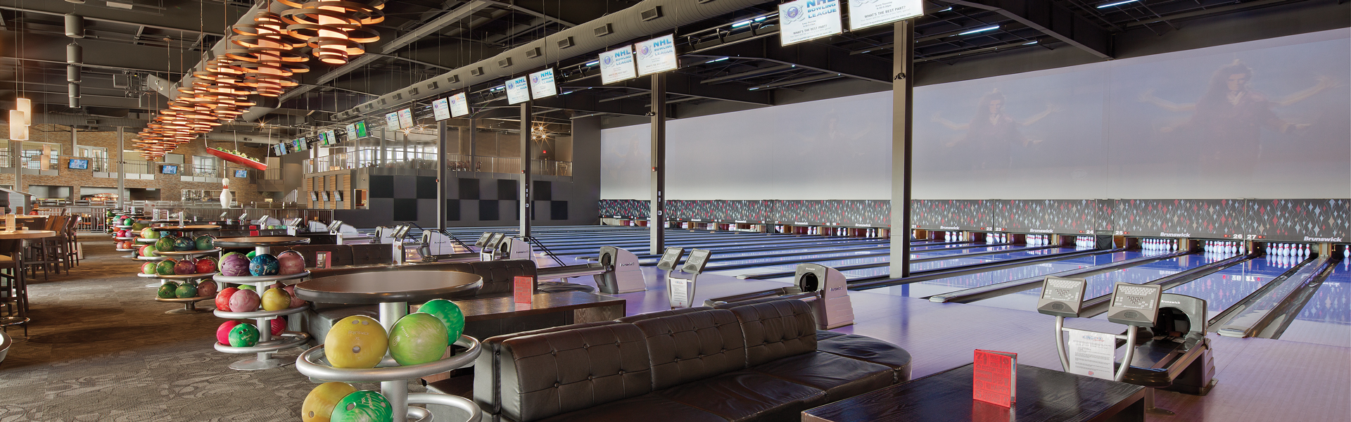 Bowling alley interior with multiple lanes, lounge seating and exposed ceiling ductwork